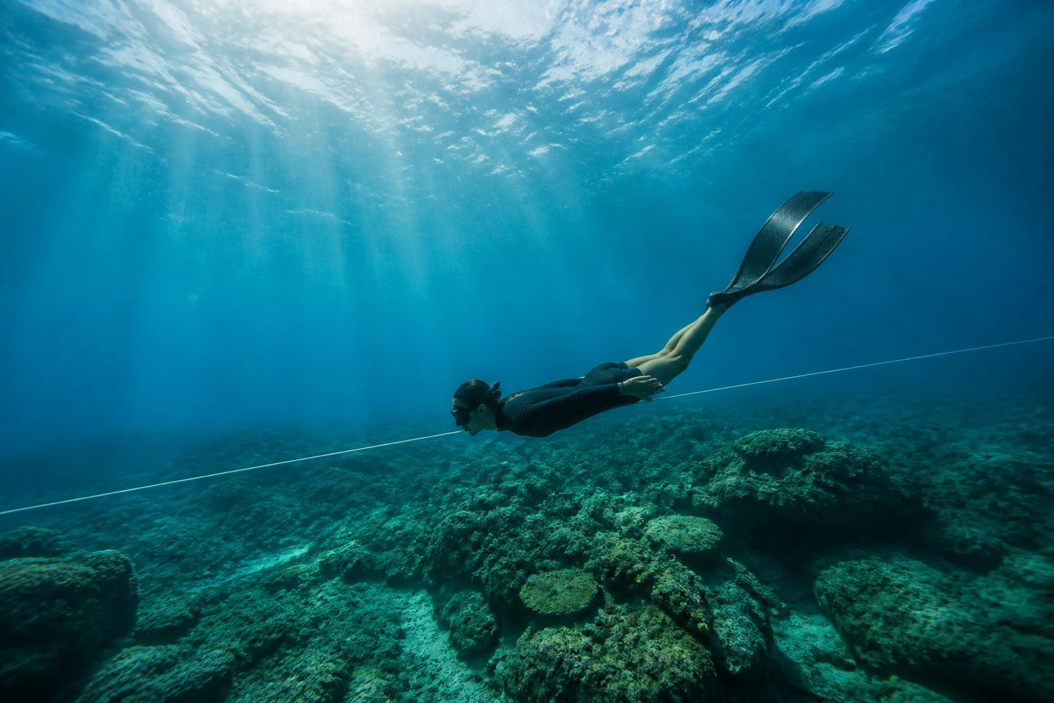 Freediver silhouette against turquoise surface